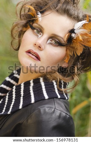 Portrait of a beautiful, charming and pretty girl with art makeup in modern fashion style