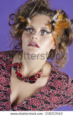 Studio portrait of a beautiful, charming and pretty girl with art makeup in modern fashion style
