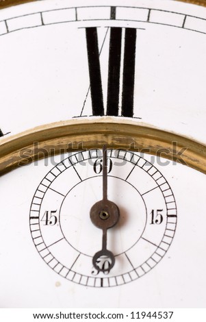 Old clock face detail with roman numerals - focus on the second hand.
