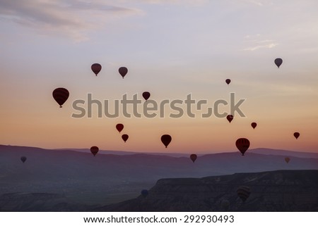 Hot air balloons flying up in the sky in silhouettes