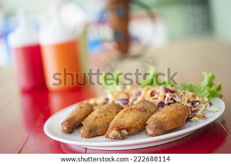 Chicken wings on the table behind with Tomato Sauce and Chilly Sauce