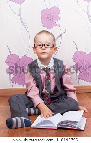 Sitting little boy with diary looks like a business man