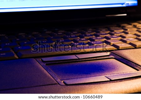 Laptop keyboard and touch-pad in blue and orange light