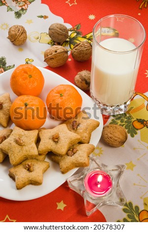 Santa\'s Cookies with galss of milk nuts candle and oranges