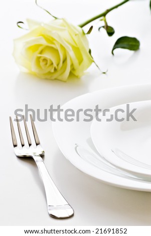 place setting with white plates and rose flower