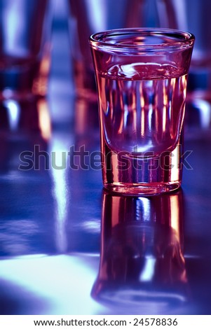 tequila shot in bar with purple and blue light and shallow depth of field