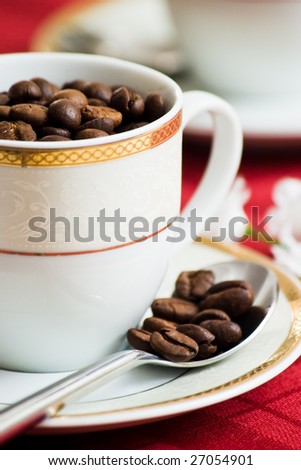 coffee beans in cup and spoon with shallow depth of field