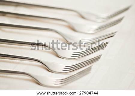 six forks on beige table cloth with shallow depth of field