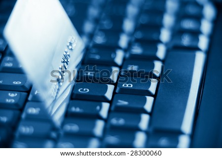 credit card on keyboard with shallow depth of field - blue toned