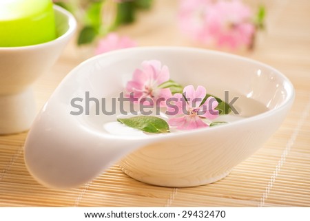 little bowl of water and flowers on bamboo board