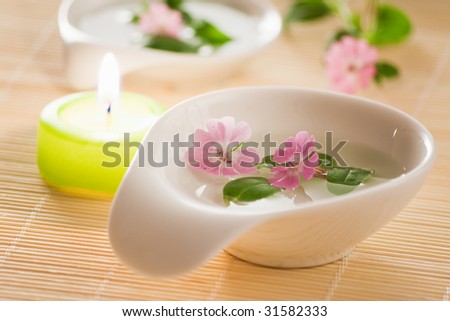 closeup of little flowers in bowl and candle