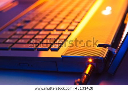 closeup of battery charge on laptop computer with power plug