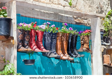 Old boots used as flower pots on the entrance door of a house, Israel