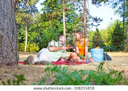 Beautiful young man and woman on picnic in summer forest
