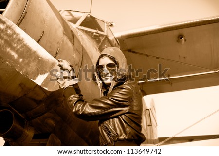 Portrait of female pilot  with plane propeller. Retro photos.