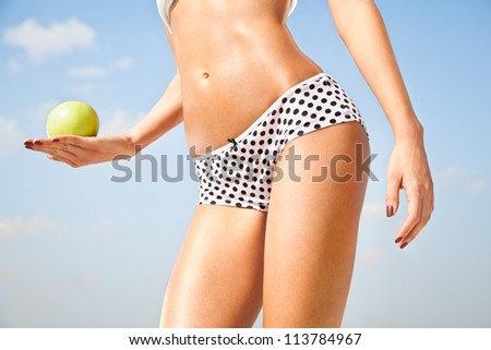 Woman perfect slim body holding an apple.  Diet, healthy life.