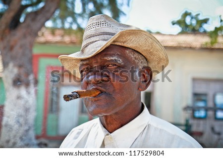TRINIDAD,CUBA - JAN.13:Cuban man smokes a cigar on January 13, 2010 in Trinidad,Cuba. Cubans of all ages are actively smoking cigars. All the production in Cuba is controlled by the Cuban government