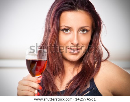 Portrait of young happy smiling cheerful beautiful woman with glass of red wine. She is this year\'s world champion in shooting.