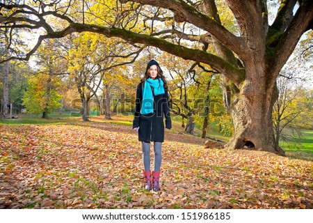 Beautiful girl in front of big tree on an sunny autumn-day in park