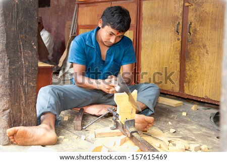 BHAKTAPUR NEPAL-MAY 20 Unidentified carpenter sawing a board in Bhaktapur Nepal on May 20 2013 Much of Nepal's economy still relies on hand tools and skilled tradesmen BHAKTAPUR NEPAL-MAY 20 Unidentified carpenter sawing a board in Bhaktapur Nepal on May 20 2013 Much of Nepal's economy still relies on hand tools and skilled tradesmen