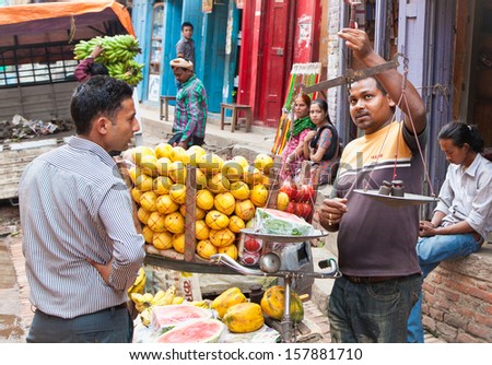 BHAKTAPUR, NEPAL - MAY 19:  Man buys fruits on  May 19, 2013 at Durbar Sqaure in Bhaktapur, Nepal.  It is one of the three royal cities in the Kathmandu valey, a very popular spot for tourists.