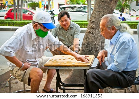 SAIGON, VIETNAM-NOVEMBER 17, 2013:Unidentified men playing board game  Xiangqi on November 17,2013 in Saigon, Vietnam.Board games have been played in most cultures and societies throughout history.