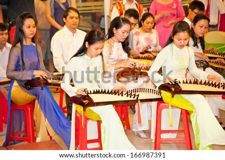 HO CHI MINH, VIETNAM- NOV 16, 2013: Unidentified Vietnamese musicians performing music on Zither, traditional instrument at the Labor Cultural Palace on Nov 16, 2013. in Saigon, Vietnam.