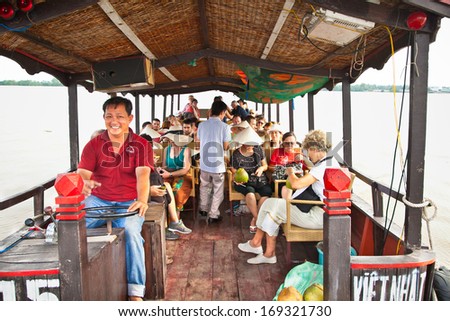 MEKONG, VIETNAM-NOV 18, 2013: Tourists traveling through the channels of the Mekong delta on Nov 18, 2013. Vietnam. Mekong Delta is home of people who live along the many channels.