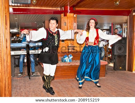 HAKIDIKI, GREECE-MAY 25, 2014: Greek folk music and dancing with traditional costume entertained tourists in Pirate ship, Greece on May 25, 2014.Pirate ship transport tourists around holy Athos,Greece
