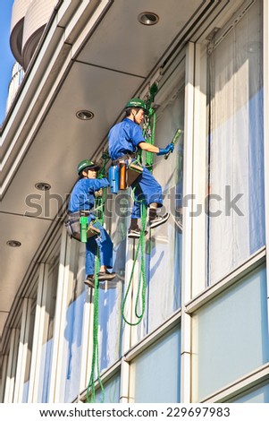 TOKYO, JAPAN- OCTOBER 28, 2014: Workers cleaning windows service on high rise building on October 28, 2014. in Tokyo, japan.