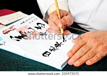 NIKKO, JAPAN - OCT 15, 2014: Hands writing japanese calligraphy Shodo on Oct 15, 2014 in Nilkko, Japan.Shodo is Japanese calligraphic art.Direct English translation for Shodo is \