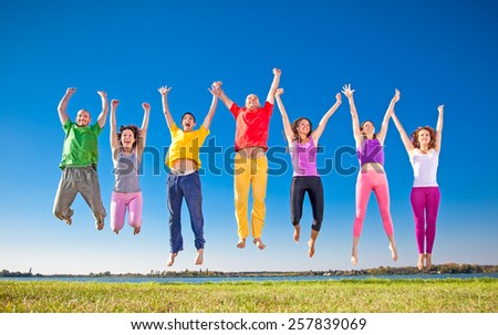 Happy smiling  group of jumping  people on banch of lake in Serbia.