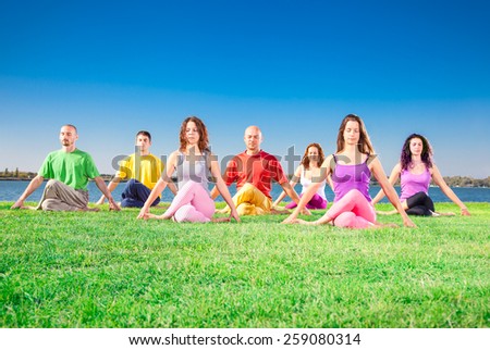 Young people practice Yoga asana on lakeside. Yoga concept.