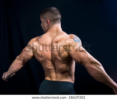 A perfect muscular man posing artistic, back double biceps