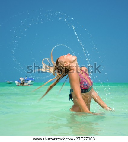 Beautiful woman throw back hair from the water at the tropical beach