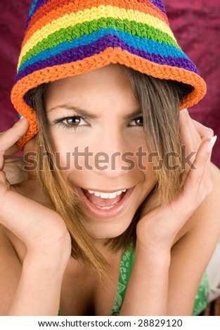 Closeup portrait of a happy young woman with color hat smiling