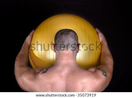 A perfect muscular man with yellow ball posing artistic,studio shot