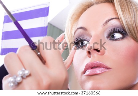 Close up of the woman  paints face with makeup
