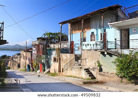 Panoramic view of street with crumbling buildings and view on a bay in Santiago de Cuba , Cuba