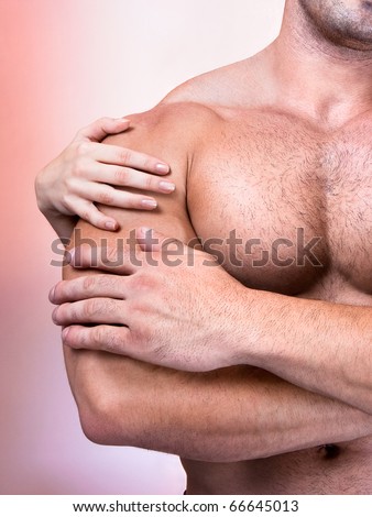 Woman's hands on a sexy man's torso, studio shot