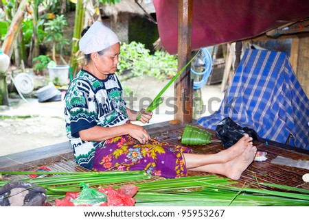 LOMBOK, INDONESIA - FEBRUARY 14 - Sasak woman make basket from leaf of palm  tree on February 14,2012 in Sade village,Lombok.Indonesia. Sasak people are skilled in making baskets for ceremonies