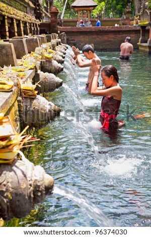 TAMPAK SIRING, BALI, INDONESIA - JANUARY 26: People praying at holy spring water temple Pura Tirtha Empul during purification ceremony on January 26, 2011 in Tampak Siring, Bali, Indonesia