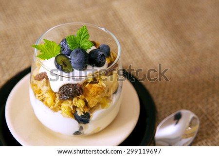 Fresh Yogurt with blueberries isolated on brown cloth background.
