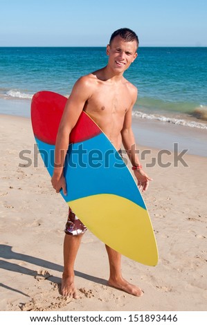 teenage boy posing with surf board in the beach