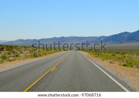 Straight and empty road with yellow lines. Nevada, US