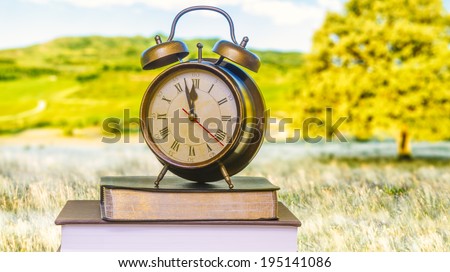 Clock over Bible in front of monitor.