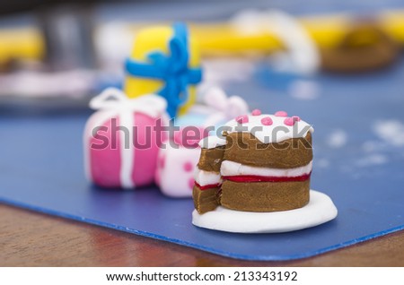 A stock photo of a tiny cake and presents made from fondant