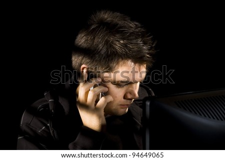 A young man listens on the phone
