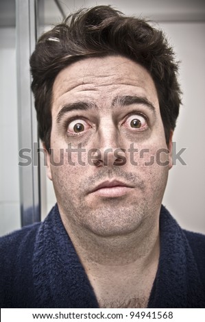 A stock photo of a man surprised by his own face the morning after a big night