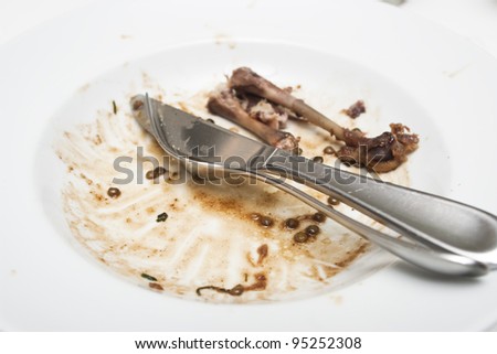 Knife and fork resting in an empty bowl